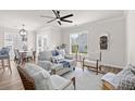 Cozy living room with comfortable seating, a ceiling fan, and lots of natural light from the surrounding windows at 113 Amaranth Ave, Summerville, SC 29483