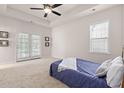 Bright primary bedroom features a large bed, French doors, and plenty of natural light at 113 Amaranth Ave, Summerville, SC 29483