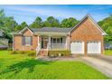 Lovely brick home features a covered porch, a two-car garage, and manicured landscaping at 115 W Park Ln, Summerville, SC 29486