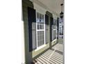 Covered porch showcasing classic columns and elegant black shutters at 116 Marshside Dr, Summerville, SC 29485