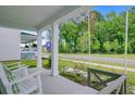 View of a front porch with white pillars, a swing, and a neighborhood street at 1226 Spotflower St, Summerville, SC 29485