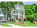 Charming two-story home with a quaint front porch and lush landscaping and palm trees in a desirable location at 1242 Schirmer St, Mount Pleasant, SC 29464