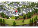 A high-angle aerial view of a property nestled within a community bordered by a scenic pond at 132 Clear Bend Ln, Summerville, SC 29486