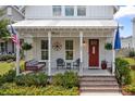 Inviting front porch featuring a swing, chairs, and charming decor, leading to a red front door at 132 Clear Bend Ln, Summerville, SC 29486