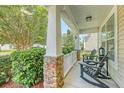 Relaxing front porch with stone-clad columns, rocking chairs, and serene outdoor view at 139 Gaslight Blvd, Summerville, SC 29483