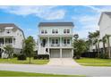 Inviting two-story home with double front porches, a well-kept lawn, and a two-car garage at 1464 Stratton Pl, Mount Pleasant, SC 29466
