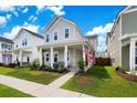 Inviting two-story home with a quaint front porch, surrounded by lush green lawn and beautiful landscaping at 1963 Longhorn Ln, Summerville, SC 29485