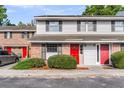 Charming townhouses showcase a harmonious blend of brick and siding, accented by sleek black shutters and vibrant red doors at 2362 Parsonage Rd # 2H, Charleston, SC 29414
