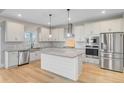 Stylish kitchen with white cabinetry, stainless steel appliances, a center island, and modern lighting fixtures at 240 Lucca Dr, Summerville, SC 29486