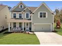 Charming two-story home featuring a cozy front porch with a swing and a well-manicured lawn at 2889 Backman St, Mount Pleasant, SC 29466