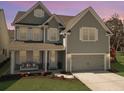 Two-story home with a welcoming front porch, swing, a two-car garage, and landscaped front yard at 2889 Backman St, Mount Pleasant, SC 29466