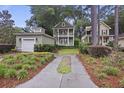 Charming two-story home with a detached garage, landscaped yard, and inviting curb appeal at 3221 Johnstowne St, Johns Island, SC 29455