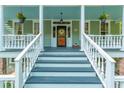 Welcoming front porch with classic columns and inviting seating, ideal for relaxing and enjoying the outdoors at 406 S Gum St, Summerville, SC 29483