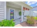 Inviting front porch adorned with patriotic decorations, potted plants, and comfortable seating, perfect for relaxing at 4314 Cotton Flat Rd, Summerville, SC 29485