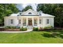Stunning white brick home with a classic design, featuring a welcoming porch with columns and shutters at 441 Elfes Field Ln, Charleston, SC 29492