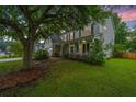 Charming two-story home with a covered front porch, mature trees, and well-maintained landscaping at 468 Maple Oak Ln, Charleston, SC 29414