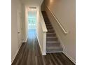 Inviting hallway with sleek wood floors, staircase with carpet runner and neutral walls at 495 Colchester Ct, Moncks Corner, SC 29461
