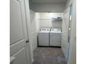 Convenient laundry room with washer, dryer, storage shelves, and dual doors at 495 Colchester Ct, Moncks Corner, SC 29461