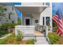 Charming porch with rocking chair and American flag provides a warm welcome to this delightful home at 5017 W Liberty Park Cir, North Charleston, SC 29405