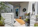A close-up of a charming front porch with a rocking chair, wreath, and potted flowers, offering a cozy curb appeal at 5017 W Liberty Park Cir, North Charleston, SC 29405