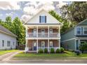 Charming two-story home features a brick facade and double balconies with lush landscaping at 5110 Hyde Park Village Ln, North Charleston, SC 29405