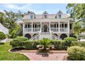 Attractive two-story home boasting a spacious porch, lush landscaping and a brick pathway to the entrance at 512 Whilden St, Mount Pleasant, SC 29464