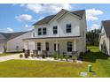 Beautiful two-story home boasting a covered front porch with stone accents, manicured lawn, and white siding at 513 Richfield Way, Summerville, SC 29486