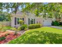 Landscaped home exterior featuring a well-maintained lawn, manicured flowerbeds, and an attached garage at 5406 E Crosland Ct, North Charleston, SC 29420