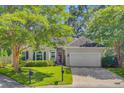 Inviting home exterior with lush trees, green lawn, and tidy landscaping at 5406 E Crosland Ct, North Charleston, SC 29420