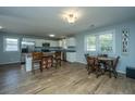 Bright kitchen and dining area with white cabinets, stainless steel appliances, and wood-look flooring at 565 Estates Dr, Walterboro, SC 29488