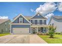 Beautiful two-story home with blue siding, a two-car garage, and a lovely front yard with landscaping at 602 Yellow Leaf Ln, Summerville, SC 29486