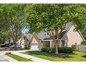 Charming home with a well-manicured lawn, mature trees, and a welcoming two-car garage at 708 Lawton Harbor Dr, Charleston, SC 29412