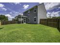 Large backyard with green grass and a screened in patio at 9680 Spencer Woods Rd, Ladson, SC 29456