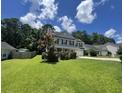 A well maintained two-story home featuring a lush lawn and complemented by mature trees on a sunny day at 1039 Steelechase Ln, Hanahan, SC 29410