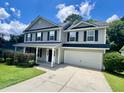 Well-maintained two-story home with gray siding, black shutters, green lawn, and a two car garage at 1039 Steelechase Ln, Hanahan, SC 29410