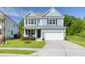 Beautiful two-story home featuring blue siding, a welcoming front porch, and a well-maintained lawn, exuding curb appeal at 105 Plowden Mill Ct, Summerville, SC 29485