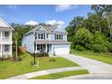 Charming two-story home with a well-manicured lawn, a cozy front porch, and a spacious driveway leading to the garage at 105 Plowden Mill Ct, Summerville, SC 29485