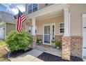 Inviting front porch with brick accents, American flag, and attractive landscaping at 1052 Whitlow Blvd, Summerville, SC 29483