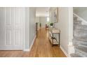 Well-lit hallway with hardwood floors, leading to the staircase and other rooms at 1052 Whitlow Blvd, Summerville, SC 29483