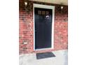 Close-up of a classic black front door framed by a red brick wall and vintage sconce lighting at 109 Ashdown Dr, Summerville, SC 29483