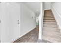 Bright foyer features hardwood floors, a staircase leading upstairs, and a white front door at 113 Cozy Nest Way, Summerville, SC 29483