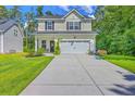 Beautiful two-story home featuring manicured front yard and attached garage on a sunny day at 115 Cooper Dr, Summerville, SC 29483