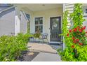 Cozy front porch with black door, welcome sign, flowers, and decorative greenery at 115 Cooper Dr, Summerville, SC 29483