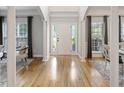 Bright foyer with hardwood floors, white pillars, and natural light, creating an inviting and open entrance at 1228 Walleye Cor, Charleston, SC 29414
