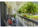 Inviting covered front porch with black rocking chairs, lanterns, and lush greenery, perfect for relaxing outdoors at 1228 Walleye Cor, Charleston, SC 29414
