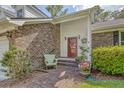 Inviting front porch with brick flooring, decorative wreath, and quaint seating area at 125 Sumners Aly, Summerville, SC 29485