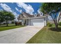 Charming one-story home with two-car garage, columned porch, and landscaped yard on a sunny day at 129 Schooner Bend Ave, Summerville, SC 29486