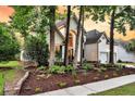 Charming two-story home with a well-manicured lawn, beautiful flower beds, and inviting curb appeal at 1311 Royal Links Dr, Mount Pleasant, SC 29466