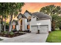 Two-story home with manicured lawn, beautiful flower beds, and a two-car garage with plenty of driveway space at 1311 Royal Links Dr, Mount Pleasant, SC 29466