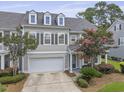 Inviting townhome with a two-car garage, dormer windows, and a beautifully landscaped yard at 132 Fresh Meadow Ln, Mount Pleasant, SC 29466